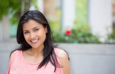 A lady smiling after dental implant in The Dental Care Center, Van Nuys, California.