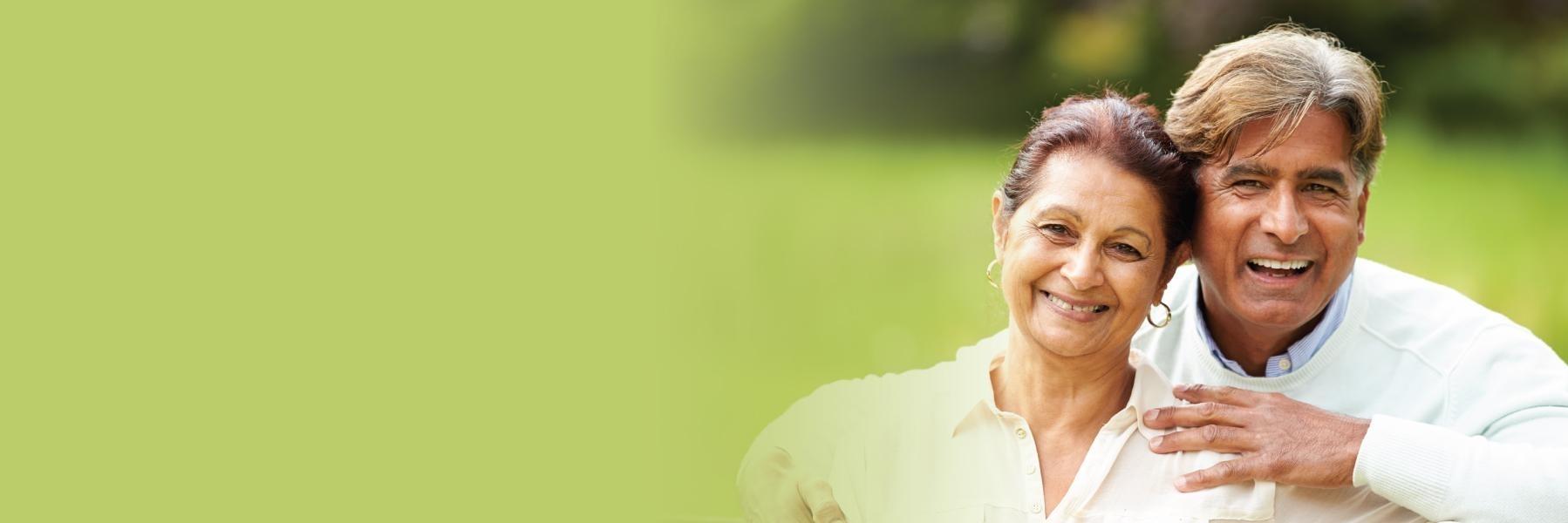 Couple smiling in grass | Van Nuys Dentist 