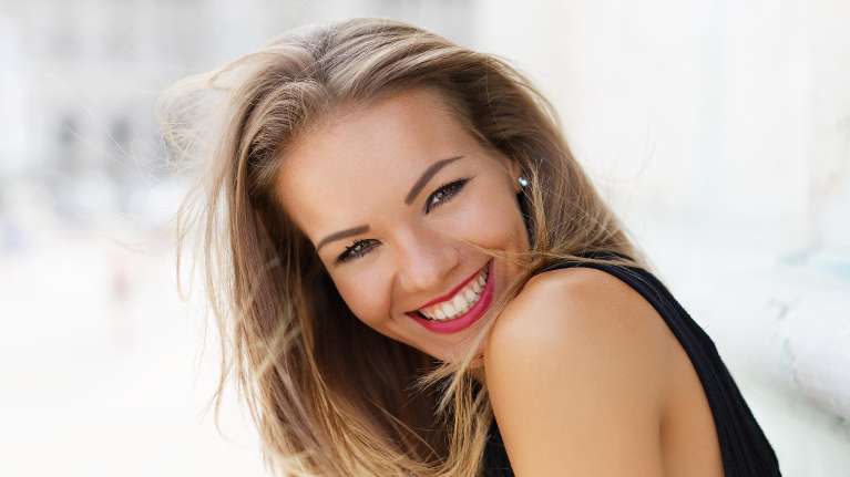 A woman after visiting The Dental Care Center for teeth whitening