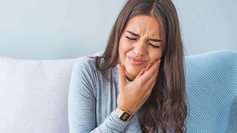 A woman in pain due to wisdom teeth trouble in Van Nuys, CA