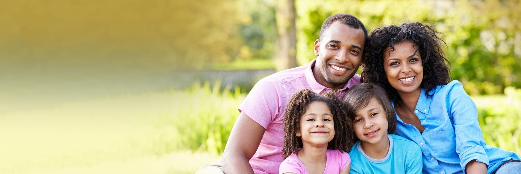 family of four outside smiling l dentists near me